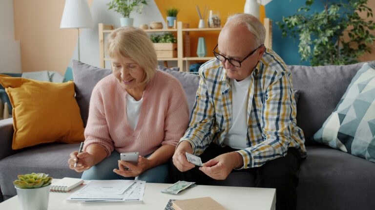 Elderly couple sits at coffee table to budget